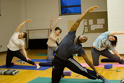 地标大学的学生在瑜伽课上做侧伸.